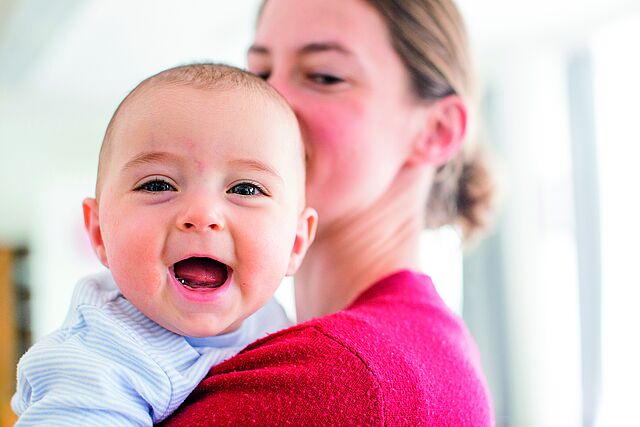 Mutter mit lächelndem Baby auf dem Arm