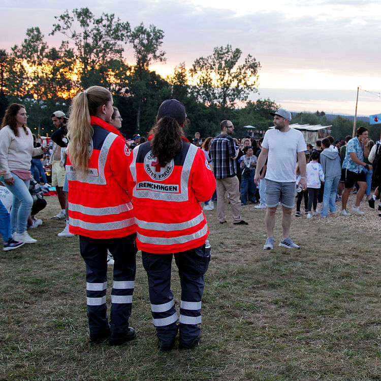 Zwei Sanitätshelferinnen passen auf dem Happiness-Festival auf und blicken aufs Publikum.